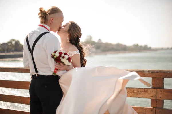 Feliz casal se beijando na ponte de madeira no fundo do mar — Fotografia de Stock