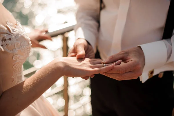 Escoba poniendo un anillo de bodas de oro a un tierno dedo de novia — Foto de Stock