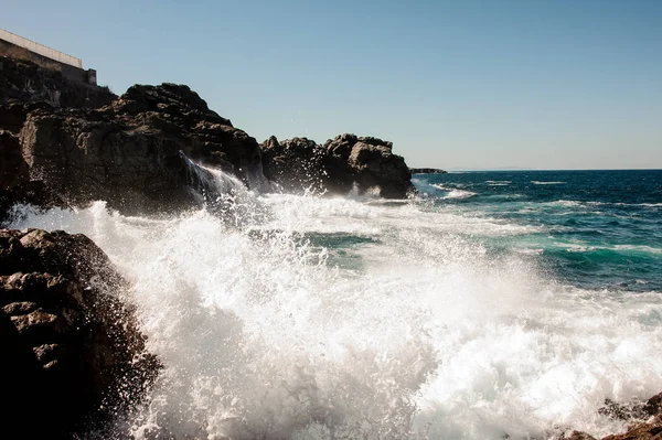 Blå djupa havet slog stenar med en vita vågor med skum — Stockfoto