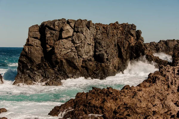 Mare scatenato che batte le rocce con onde bianche con schiuma — Foto Stock