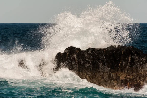 Ondata alta di mare tempestoso che batte la roccia — Foto Stock