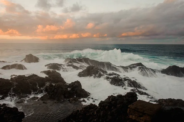 Stormiga azurblå havet och en massa stenar under molniga himmel — Stockfoto