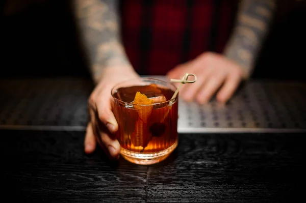 Cantinero sirviendo una copa de un cóctel Old Fashioned en el mostrador del bar — Foto de Stock