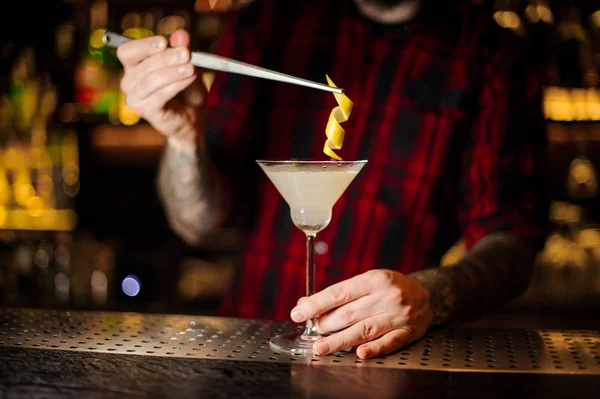 Barman dekorera fräsch syrlig och söt cocktail med ett apelsinskal — Stockfoto