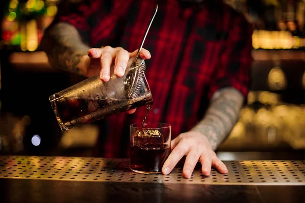 Barman verter cóctel alcohólico fuerte fresco en un vaso en el bar — Foto de Stock
