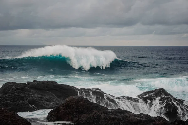 Zee Golf Met Schuim Zwarte Rots Onder Bewolkte Grijze Hemel — Stockfoto