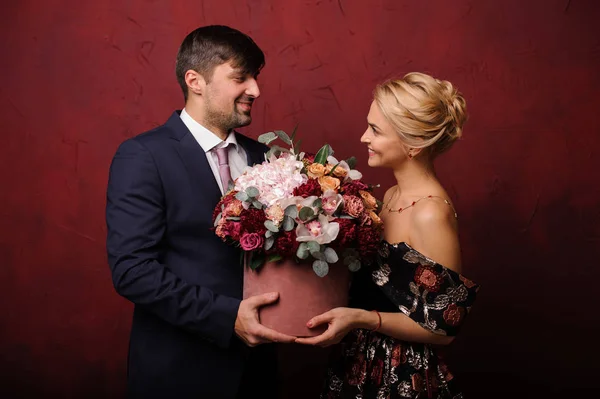Mężczyzna i kobieta trzyma bukiet kwiatów, patrząc w oczy — Zdjęcie stockowe