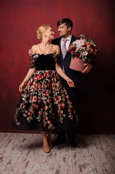 Young man holding a bouquet of flowers hugging his beautiful woman