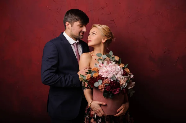 Ung man krama sin kvinna med buketten av blommor och titta i hennes ögon — Stockfoto