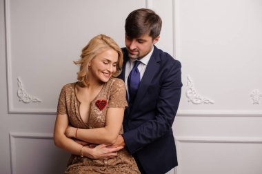 Esmer adam gülümseyerek güzel sarışın kadın sarılma