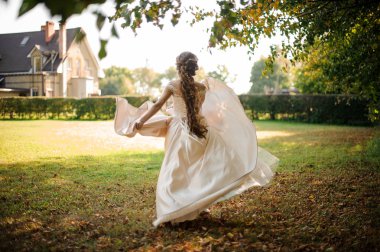 Sonbahar parkta çalışan beyaz bir gelinlikle güzel gelin