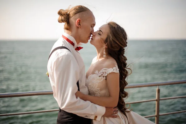 Apenas casado menino e menina beijando uns aos outros no cais no lago — Fotografia de Stock