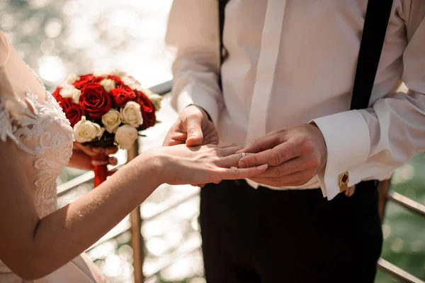Mann legt seiner Verlobten einen Ring an den Finger, der auf der Seebrücke steht — Stockfoto