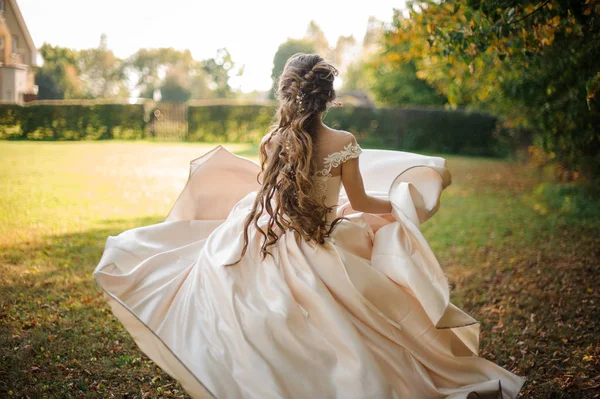 Красива наречена в білій весільній сукні, що біжить в парку — стокове фото