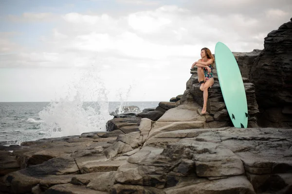 Menina Atraente Maiô Multi Colorido Sentado Perto Surf Rocha Fundo — Fotografia de Stock