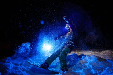 Dağ yamacında bir yeşil spor giyim standind giymiş kadın snowboard