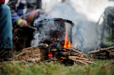 Ateşin ortasına arkadaş grubu arka plan üzerinde siyah pan duran