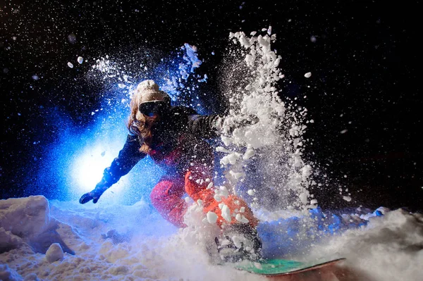 Dağ yamacında sürme bir portakal spor giyim giymiş aktif kadın snowboard — Stok fotoğraf