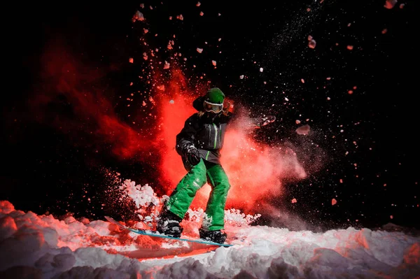 Femme active snowboarder vêtue d'un vêtement de sport vert sautant sur la neige — Photo