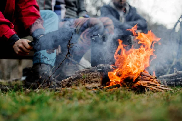 Mann winkt mit einem Schlag auf die Pfanne am Lagerfeuer — Stockfoto