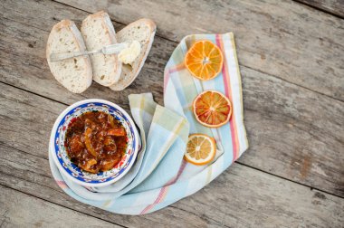 Yukarıdan güzel süslü plaka üzerinde bir lezzetli portakal reçelli ekmek yakınındaki kurutulmuş portakal peçeteyle üzerinde göster