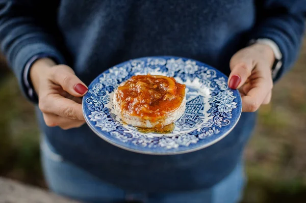 Gadis memegang piring hiasan biru dengan selai jeruk lezat pada roti — Stok Foto