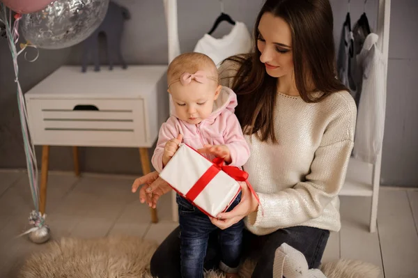 Mujer y su linda hijita sosteniendo un regalo — Foto de Stock