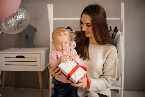 Mujer y su pequeña hija sosteniendo un regalo — Foto de Stock