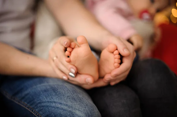 Woman holding her little daughter trotters on hands — Stock Photo, Image