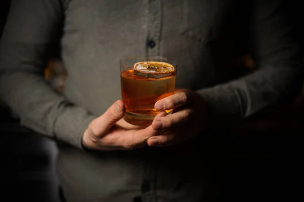 Бармен подает вкусный коктейль с сушеным апельсином — стоковое фото