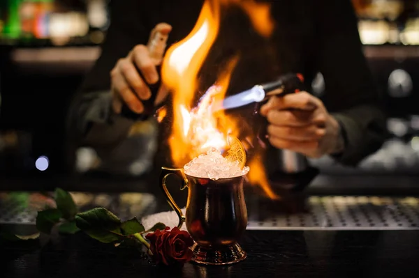 Barkeeper sprüht den Cocktail in der goldenen Tasse an und entzündet ihn — Stockfoto