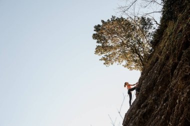 Kadın bir ip üzerinde eğimli kaya tırmanışı ile donatılmış
