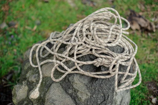 Climbing rope casually laid on a rock in the nature — Stock Photo, Image