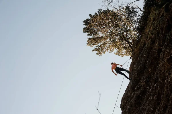 Vrouw uitgerust met een touw abseilen op de hellende rots — Stockfoto