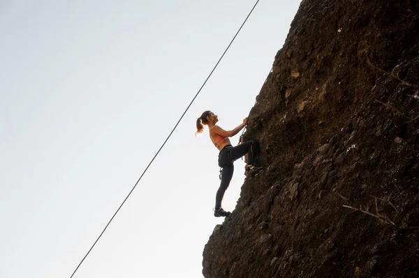 Woman equipped with a rope climbing on the sloping rock — Stock Photo, Image