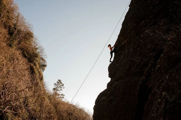 Sportieve meisje uitgerust met een touwklimmen op de hellende rots — Stockfoto