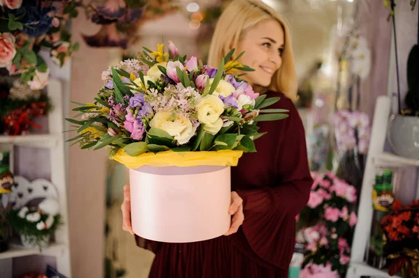 Mujer rubia sosteniendo caja del sombrero con flores —  Fotos de Stock