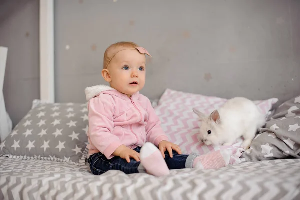 Linda niña jugando con conejo blanco — Foto de Stock