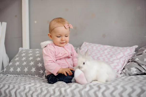Linda niña jugando con conejo blanco — Foto de Stock