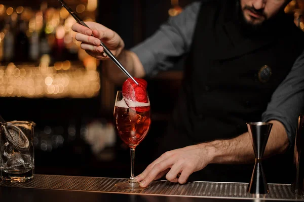 Barman profissional adicionando a um delicioso cocktail decoração de fatia vermelha — Fotografia de Stock