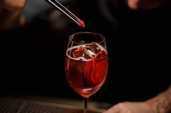 Professional bartender adding to a delicious cocktail decor of the little rose bud — Stock Photo, Image