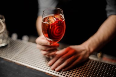 Lezzetli bir kokteyl kırmızı sebze dilim bir dekor ile hizmet veren profesyonel barmen