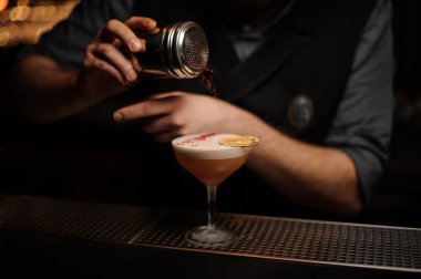 Profesyonel barmen için lezzetli bir kokteyl kırmızı tatlar ekleyerek bir baharat shaker holding