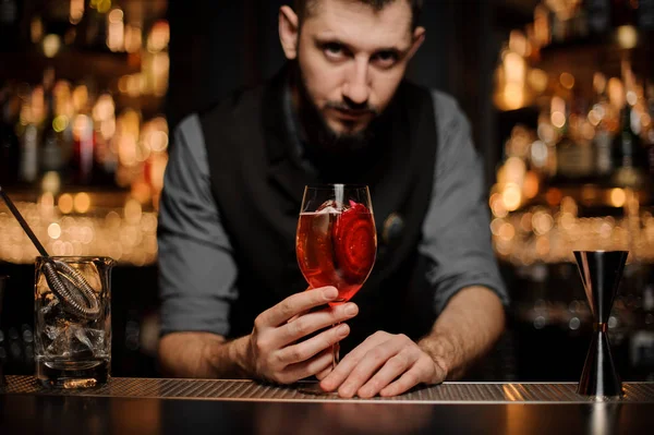 Barkeeper serviert einen köstlichen Cocktail mit einem Dekor aus roten Scheiben — Stockfoto
