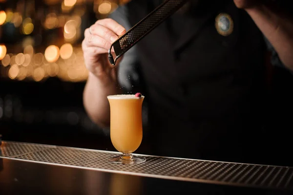 Professional bartender adding to a delicious cocktail spice from the grater — Stock Photo, Image