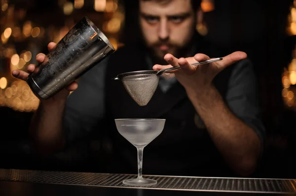 Profesjonalny barman leje koktajl z shaker przez specjalne sito — Zdjęcie stockowe