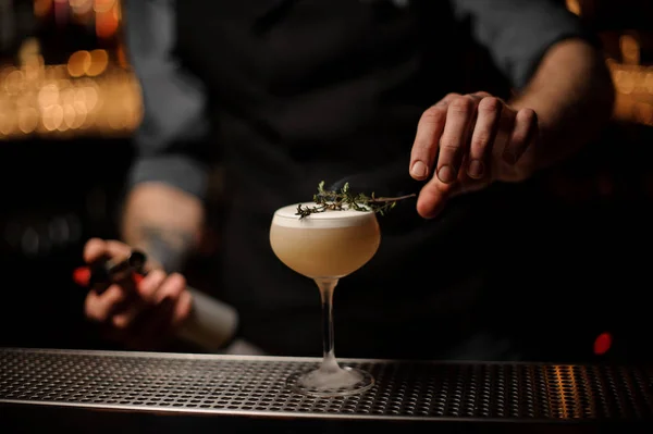 Barman professionnel ajoutant à un verre à cocktail d'herbes fumées — Photo
