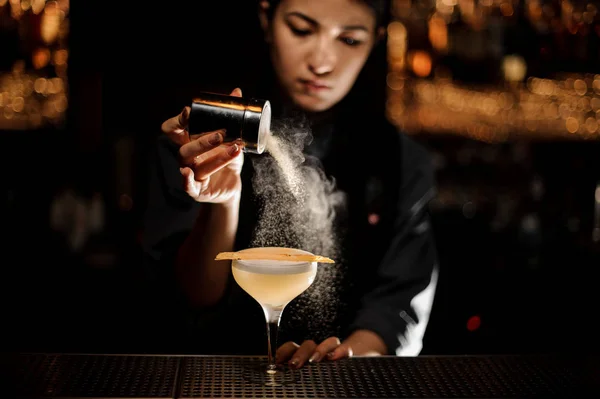 Barman dziewczyna gospodarstwa shaker przyprawy, dodając do pyszne smaki koktajl — Zdjęcie stockowe