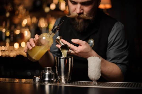 Cantinero sirviendo una deliciosa bebida alcohólica del jigger de acero — Foto de Stock