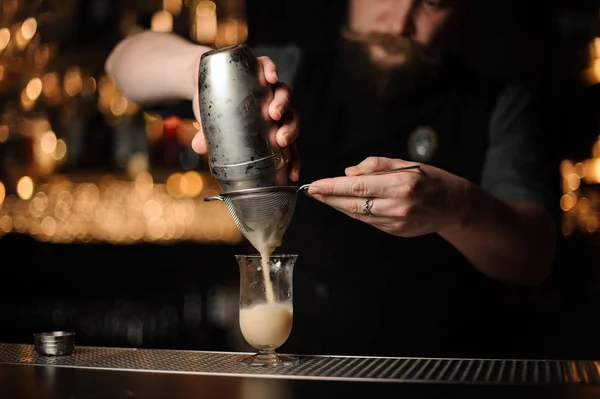 Barman professionnel versant cocktail du shaker à travers le tamis — Photo